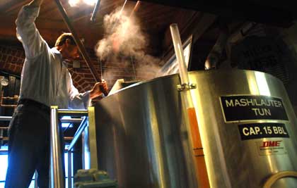 James Ottolini stirs fresh hops into mash/lauter tun used as hop back